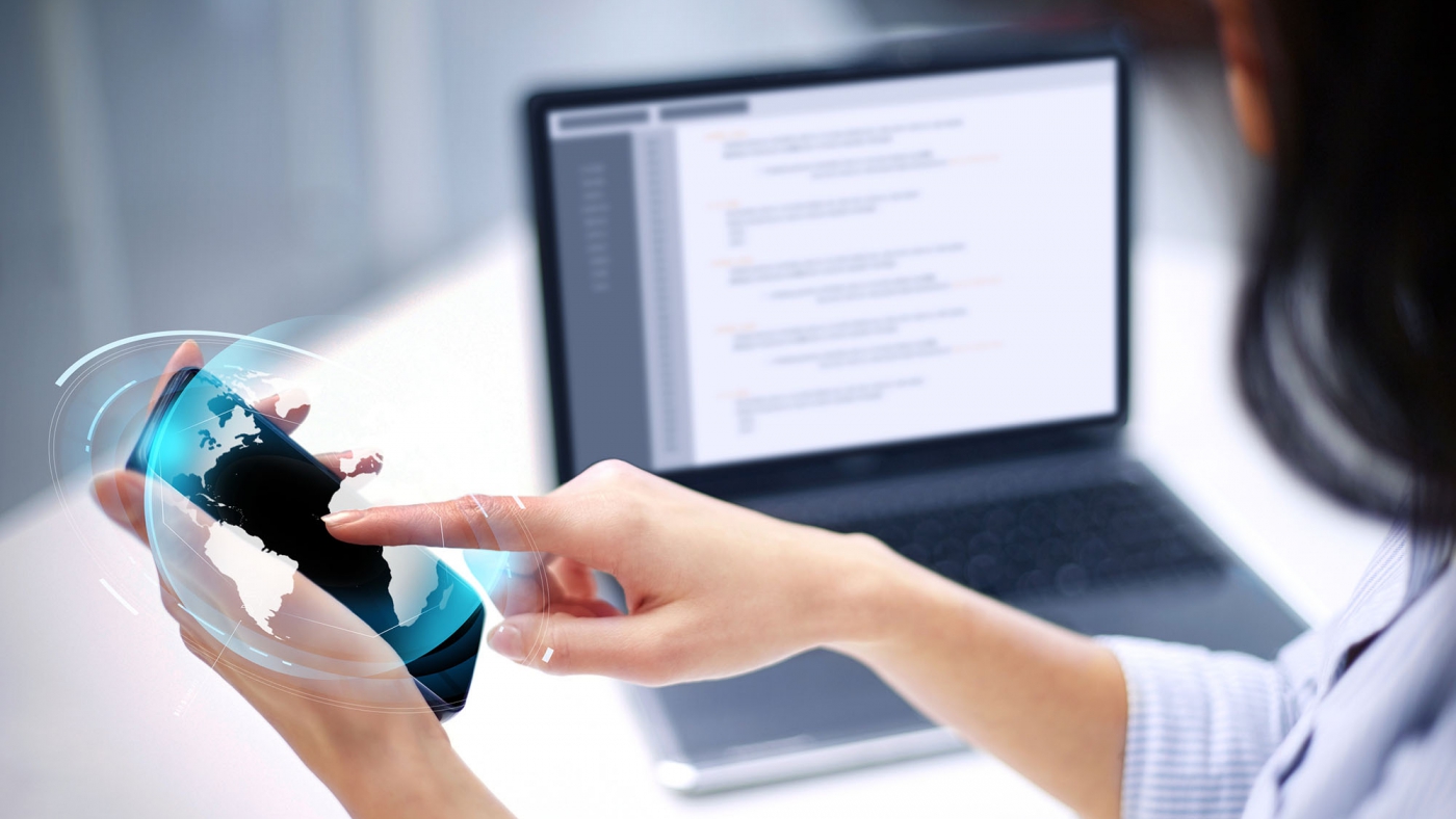 business, technology and people concept - close up of businesswoman with smartphone and earth hologram at office